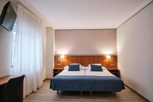 A bed or beds in a room at Hotel Ciudad de Compostela