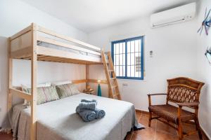a bedroom with a bunk bed and a chair at Casa Ardisia, con terraza y aparcamiento in Las Negras