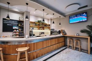 a bar with two stools and a tv on the wall at Hotel Ciudad de Compostela in Santiago de Compostela