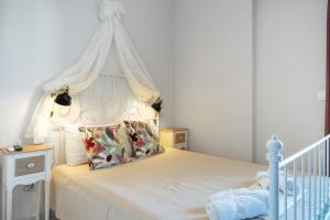 a bedroom with a white bed with a canopy at Katerina Irida Kythnos in Mérikhas