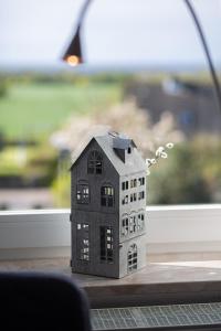 a toy house sitting on a table in front of a window at "Ferienhof Sporleder" - Bauernhaus 2 in Meeschendorf