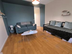 una sala de estar con un sofá y una mesa en Le charme Centre Parking wifi, en Châteauroux