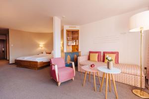 una stanza d'albergo con un letto, un divano e un tavolo di Hotel Hohenwart a Scena