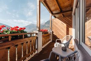 un balcone con tavolo, sedie e fiori di Hotel Hohenwart a Scena Altre 7 foto