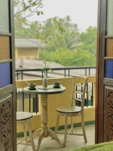 The Vitamin Sea في أمبالانغودا: طاولة وكراسي يجلسون على شرفة مع نافذة