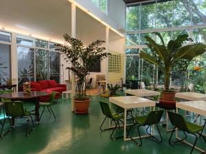 a large room with tables and chairs and plants at Cochet in Chiang Mai