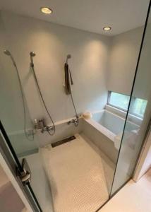 a bathroom with a shower and a bath tub at 鹿島サーフヴィラ in Iijima