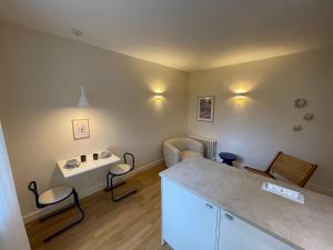 een kleine woonkamer met een tafel en een bank bij Ajania, Appt avec parking et petit jardin privé in Caen +7 foto's