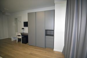 a room with a desk and a kitchen with white cabinets at Franciacorta Karting Rooms in Castrezatto