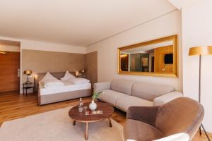 un soggiorno con un divano e un tavolo di Hotel Hohenwart a Scena Altre 37 foto