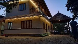 a man standing in front of a house at Heritage Farm Kerala in Idukki