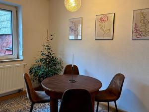 a dining room with a wooden table and chairs at Wohnen am Main in Würzburg