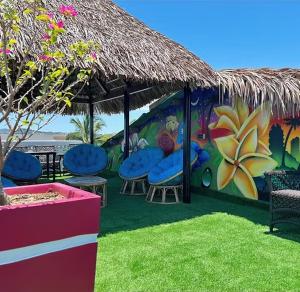 a painting of a garden with chairs and a umbrella at VaoVao Hotel in Nosy Be