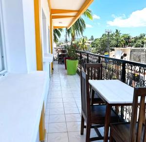 a balcony with tables and chairs on a building at VaoVao Hotel in Nosy Be
