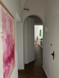 a hallway with a pink painting on the wall at Swanky Residence, 4 stars, city centre in Ljubljana