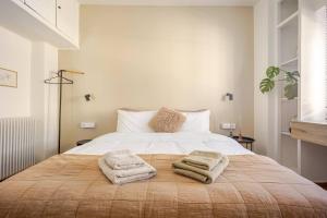 a bedroom with a large bed with towels on it at Marthas Loft Lycabettus Athens in Athens