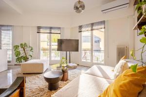 a living room with a couch and a tv at Marthas Loft Lycabettus Athens in Athens