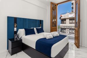 ein Schlafzimmer mit einem großen Bett mit blauem Kopfteil in der Unterkunft 7 Luxury Suites By Karat in Santa Cruz de Tenerife