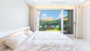 - une chambre avec un lit et une vue sur une terrasse dans l'établissement Gapyeong staysumok pool villa pension, à Gapyeong