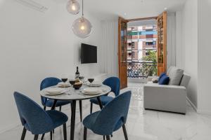 ein Esszimmer mit einem Tisch und blauen Stühlen in der Unterkunft 7 Luxury Suites By Karat in Santa Cruz de Tenerife