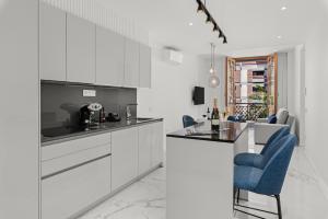 eine Küche mit weißen Schränken und blauen Stühlen in der Unterkunft 7 Luxury Suites By Karat in Santa Cruz de Tenerife