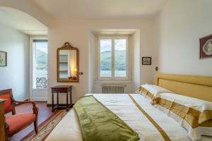 une chambre avec deux lits, un miroir et des fenêtres dans l'établissement Lakefront 1800s Villa Private Dock, Art Luxury, à Carate Urio