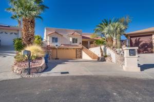 une maison avec des palmiers en face d'une allée. dans l'établissement Peruvian-4 Bed Desert Oasis -Pool, Hot-Tub &Outdoor Kitchen, à Lake Havasu City