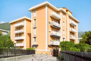 Un edificio alto de color naranja con una valla delante. en Casa Ester, en Arenzano