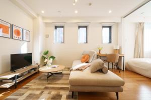 a living room with a couch and a tv and a bed at Space Roppongi in Tokyo