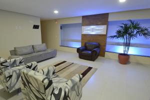 uma sala de estar com um sofá e uma cadeira em Pousada Da Serra em Bananeiras