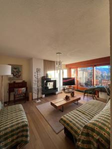 a living room with two beds and a fireplace at Renovated Mountain View Apartment - Les Eperviers in Crans-Montana