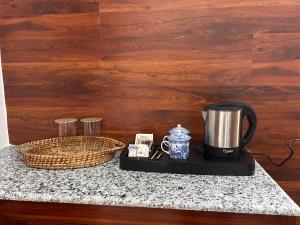 a coffee maker and a basket on a counter at Zen Resort Shergaon in Shergaon