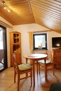 une salle à manger avec une table et des chaises et une télévision dans l'établissement Gästehaus Seewald- Ferienwohnung 7 "Eiche", Schluchsee, Blasiwald, à Schluchsee