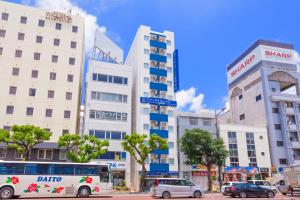 那霸Living Inn Asahibashiekimae Anex的街道前有汽车和公共汽车