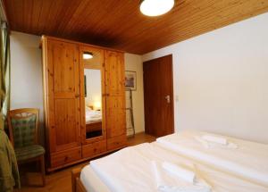 une chambre avec un lit et une armoire en bois dans l'établissement Gästehaus Seewald- Ferienwohnung 1 "Ahorn", Schluchsee, Blasiwald, à Schluchsee