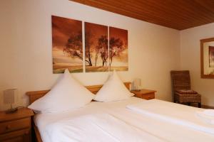 une chambre avec un lit blanc avec deux oreillers dans l'établissement Gästehaus Seewald- Ferienwohnung 1 "Ahorn", Schluchsee, Blasiwald, à Schluchsee