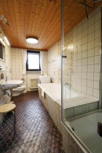 une grande salle de bain avec une baignoire et un lavabo dans l'établissement Gästehaus Seewald- Ferienwohnung 1 "Ahorn", Schluchsee, Blasiwald, à Schluchsee 21 autres photos