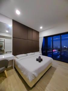 ein Schlafzimmer mit einem großen weißen Bett und einem großen Fenster in der Unterkunft M City 2 DUPLEX BEDROOM KLCC in Kuala Lumpur