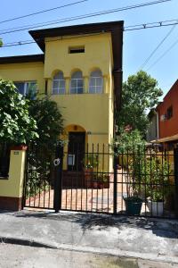 una casa amarilla con una valla negra delante en Marcos Studio Apartment, en Bucarest