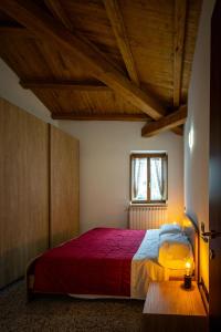 a bedroom with a large bed with a red blanket at Casa nel Borgo -Affitti Brevi Italia in LʼAquila