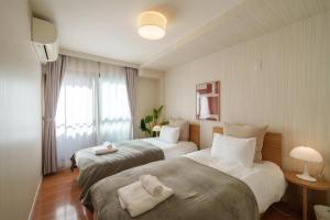 a hotel room with two beds and a window at Roppongi Place in Tokyo