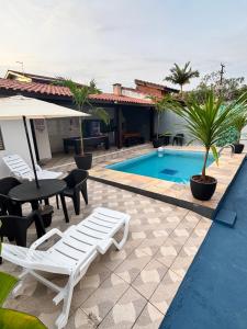 a resort with a pool and a table and chairs at Casa no Condomínio CenterVille in Bertioga