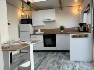 a kitchen with white cabinets and a wooden table at La petite saline in Le Croisic +20 photos