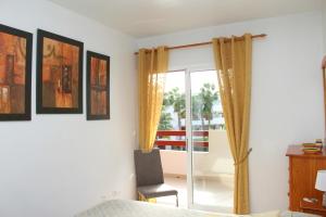 a bedroom with a bed and a chair and a window at Inviting 2 bedroom apartment in Alicante