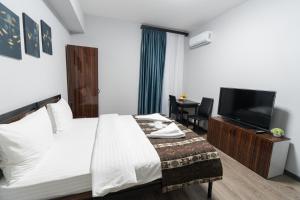 a hotel room with a bed and a flat screen tv at GH Family Hotel in Yerevan