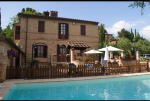 a house with a fence next to a swimming pool at Appartamenti Leccino e Moraiolo in Siena