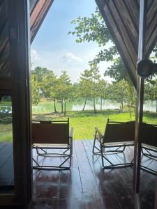 two chairs on a porch with a view of a field at 385 Glamping in Ban Khai Nao (1)