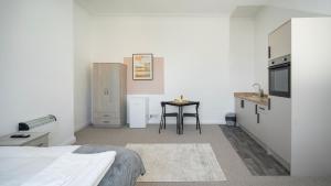 Una habitación con una cama y una cocina con una mesa. en YSS The Church 1 Coatham, en Redcar