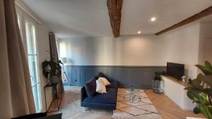 a living room with a blue couch and a tv at Appartement des Augustins in Aix-en-Provence
