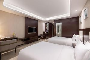 上海市にあるShangHai LuAn Garden Hotelの大型ベッドとテレビが備わるホテルルームです。